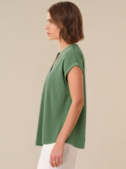 Woman wearing a green top against a beige background