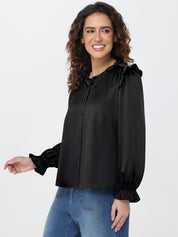 Woman wearing a black blouse with ruffled sleeves on a white background
