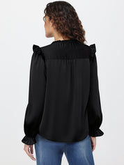 Woman wearing a black blouse with ruffled shoulders on a white background