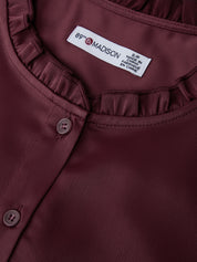 Close-up of a maroon shirt with a brand label on the collar.