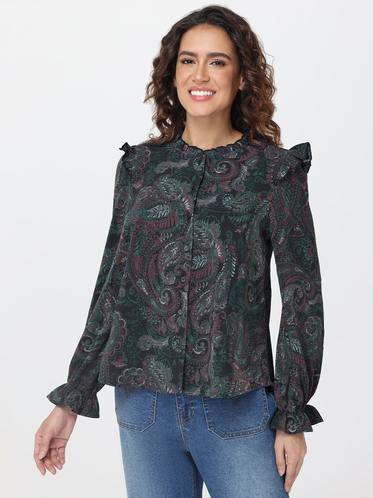 Woman wearing a patterned blouse with ruffled shoulders on a white background