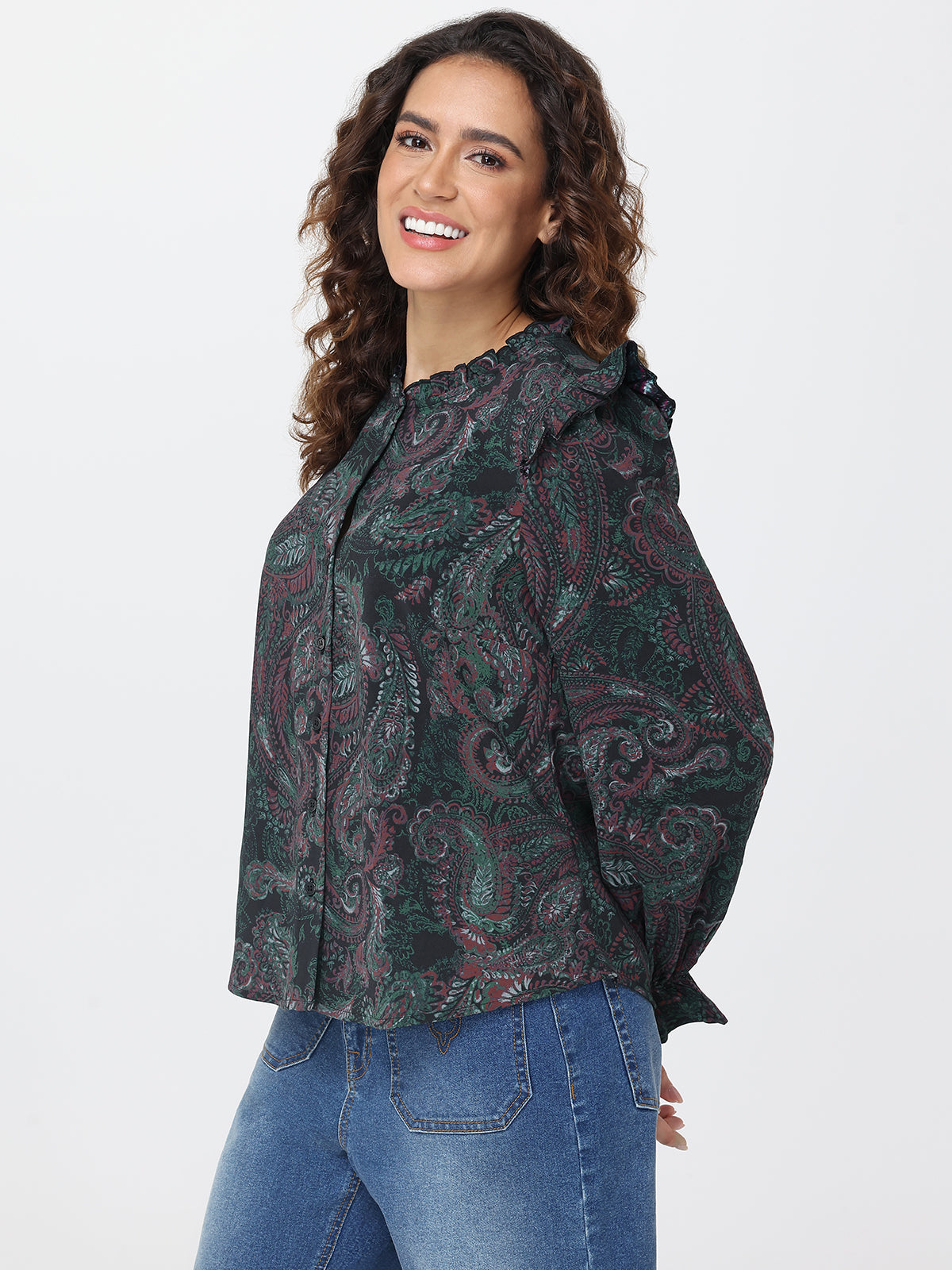 Woman wearing a patterned shirt and jeans on a white background