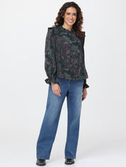 Woman wearing a patterned top and blue jeans on a white background