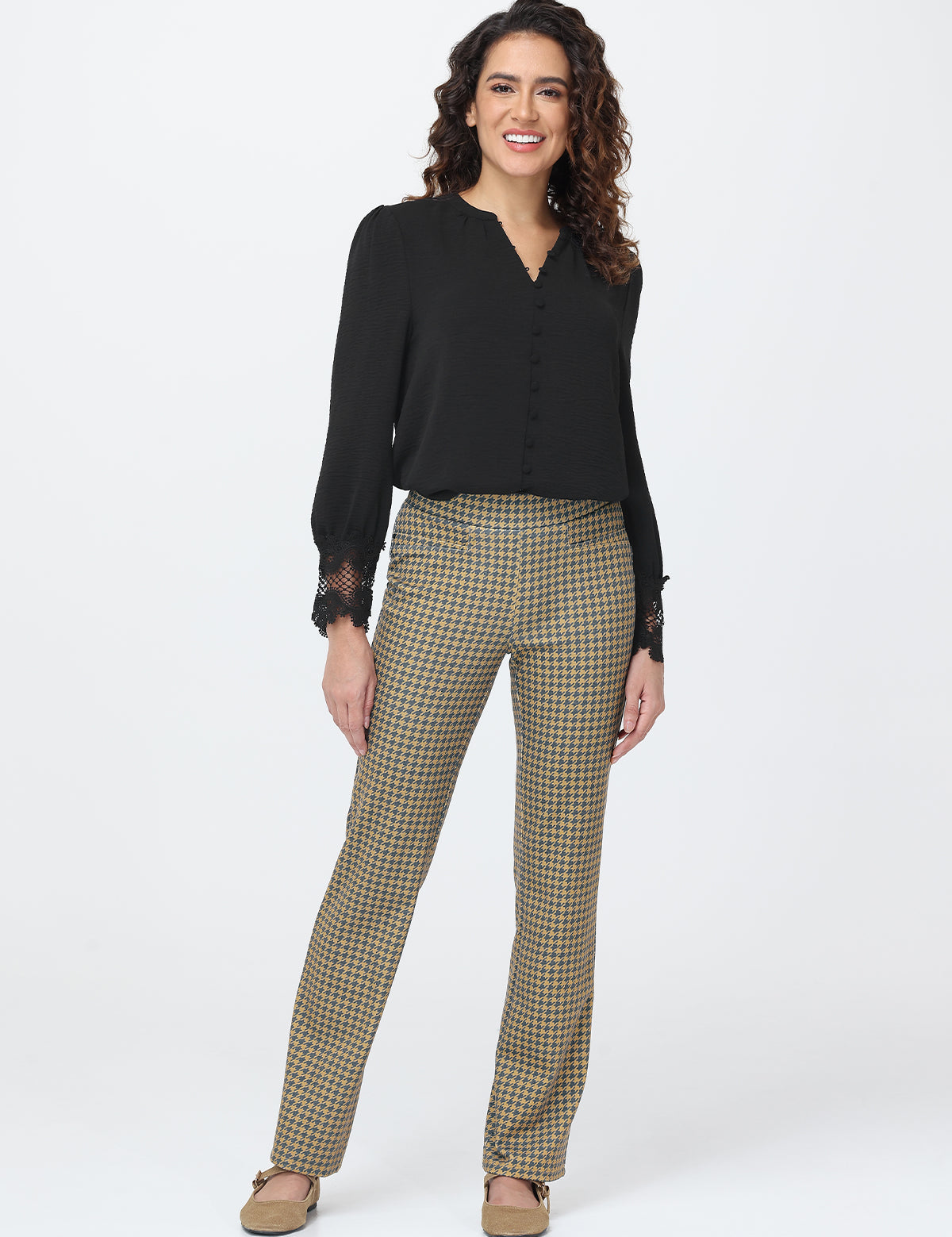Woman wearing a black top and plaid pants on a white background