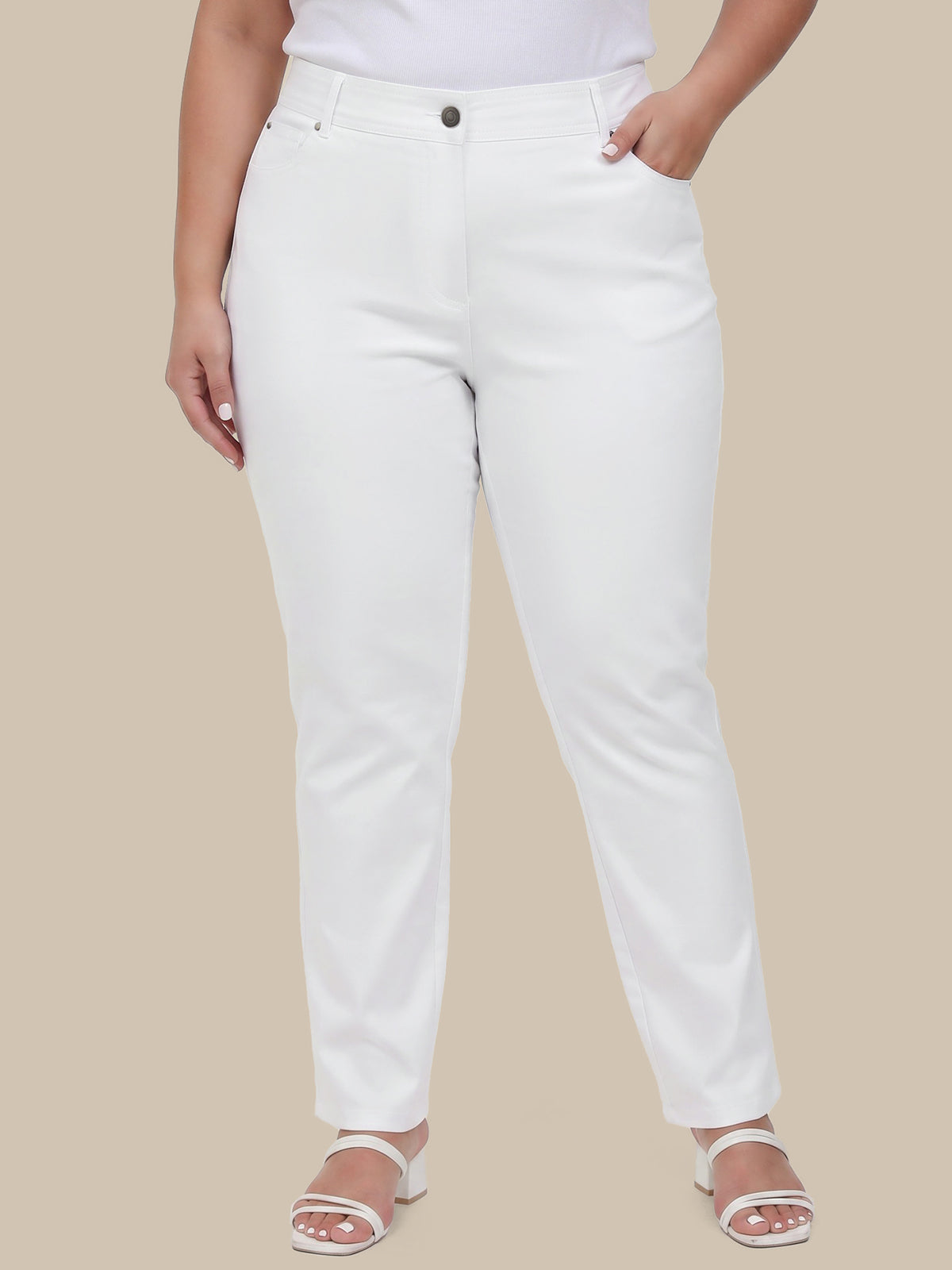 Person wearing white pants on a beige background