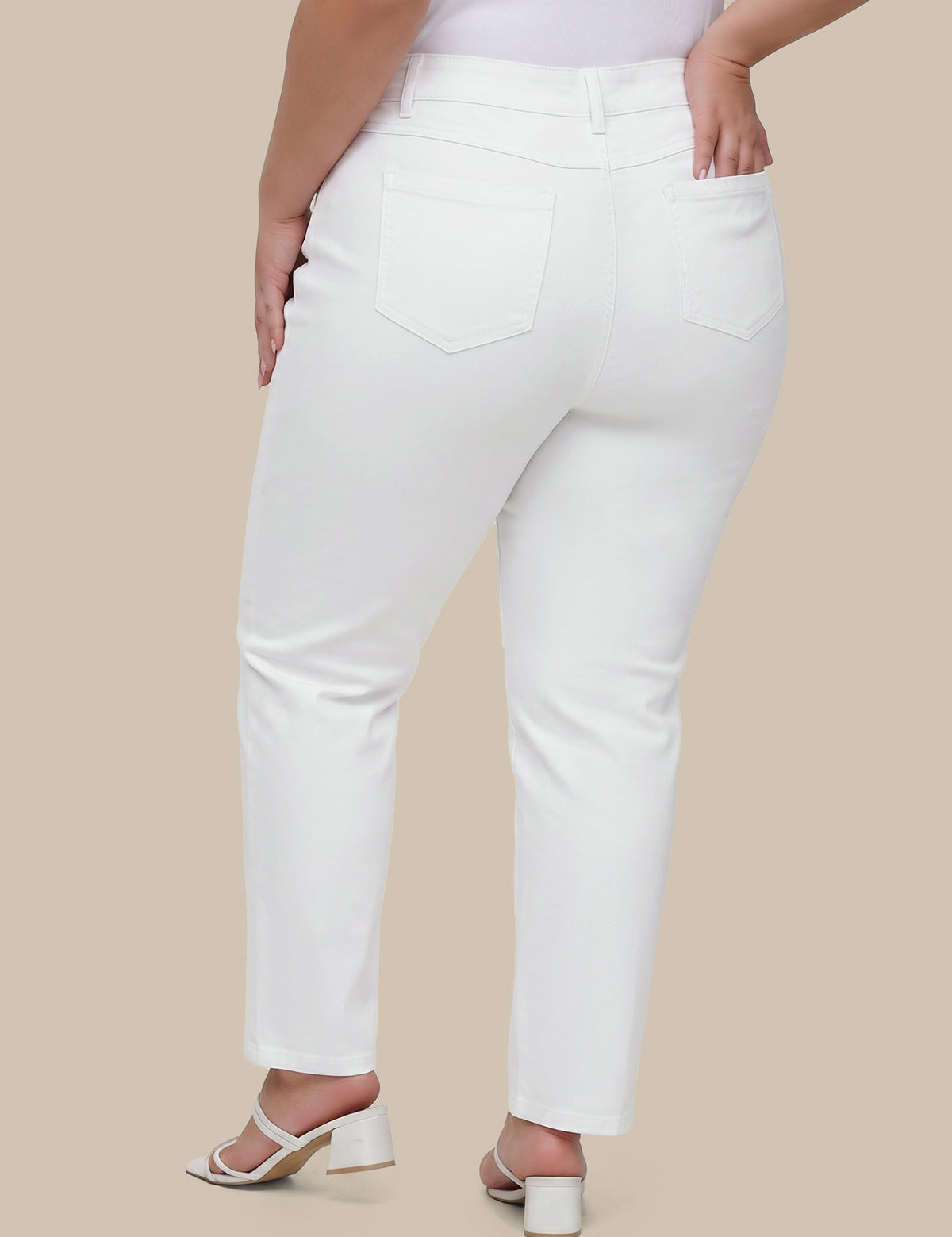 Person wearing white jeans on a beige background