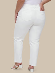 Person wearing white jeans on a beige background
