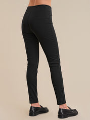 Black pants worn by a person on a beige background