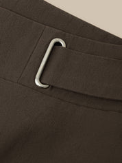 Close-up of a dark brown fabric belt with a silver-toned metal buckle on a matching belt loop.