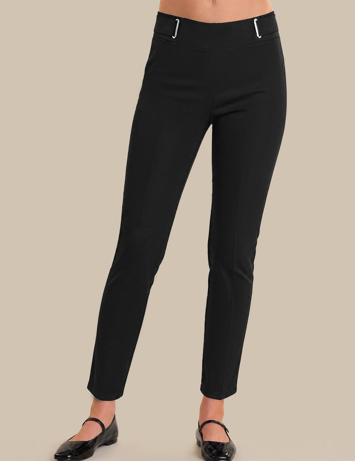 Black pants worn by a person on a beige background