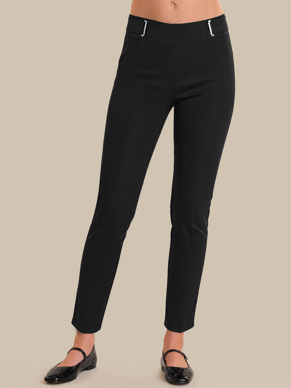 Black pants worn by a person on a beige background