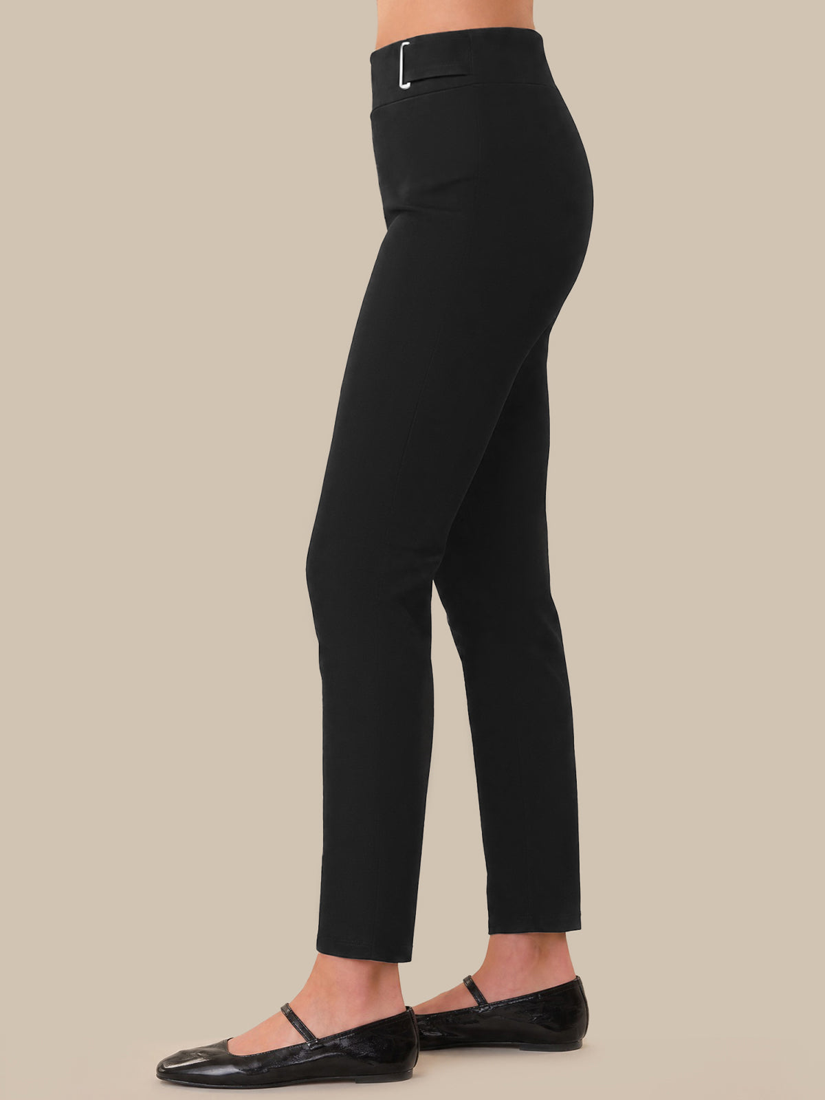 Black pants worn by a person on a beige background