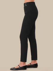 Black pants worn by a person on a beige background