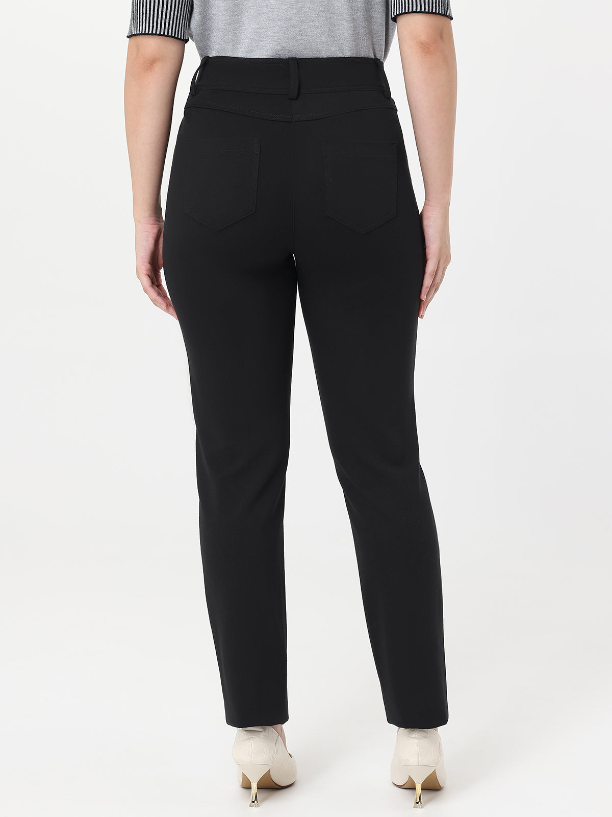 Black pants worn by a person on a white background