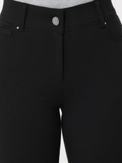 Close-up of black pants with a button on a white background