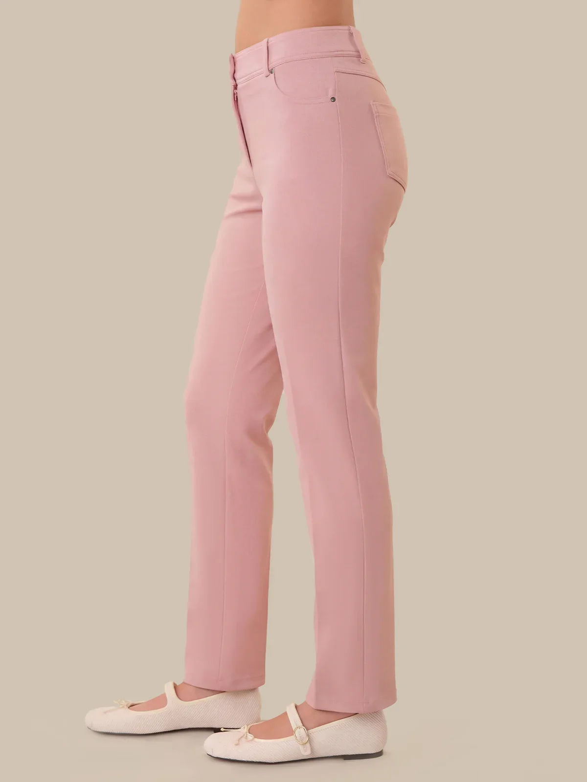 Pink pants worn by a person on a beige background