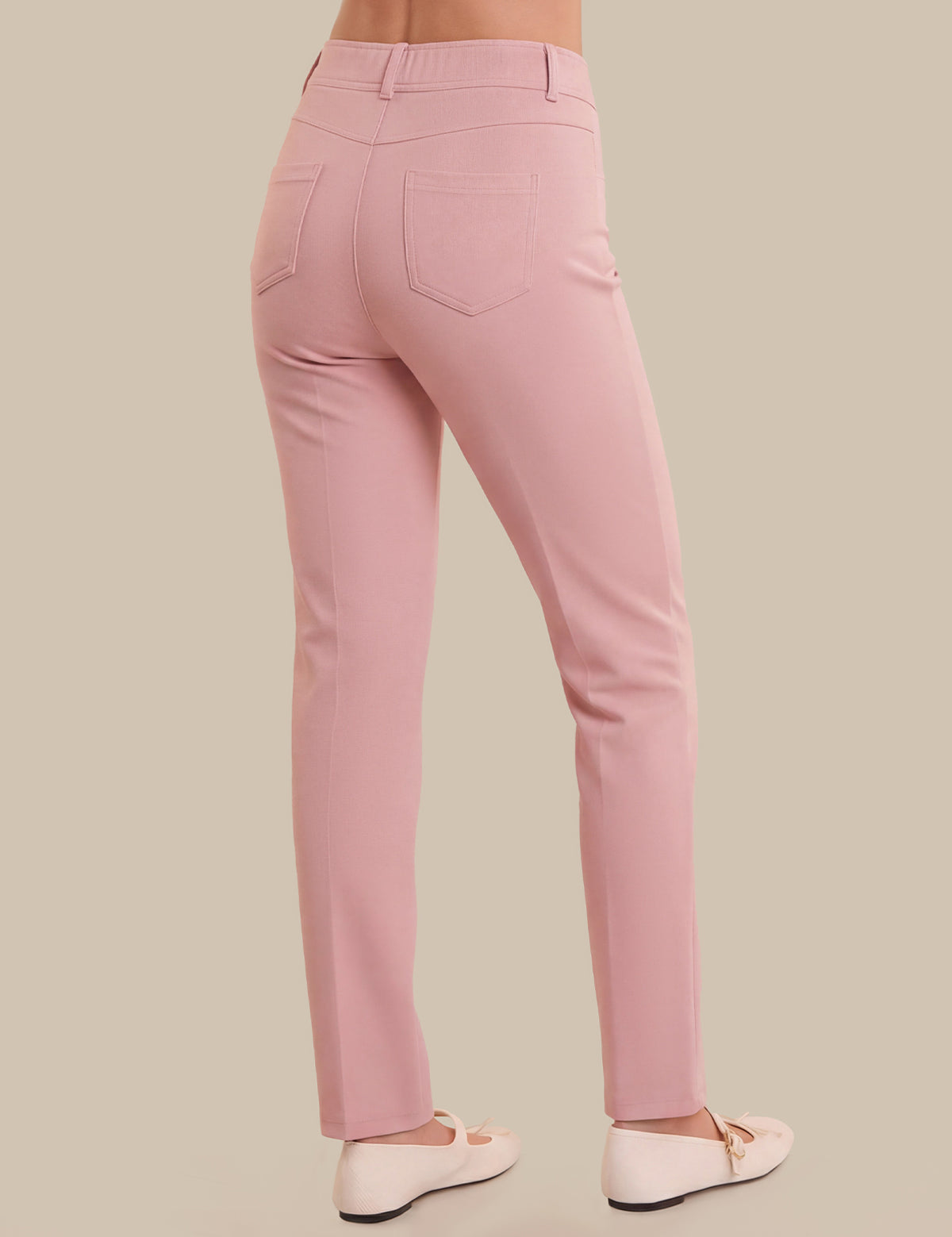 Pink pants worn by a person on a beige background