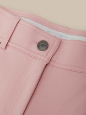 Close-up of pink pants with a button on a beige background