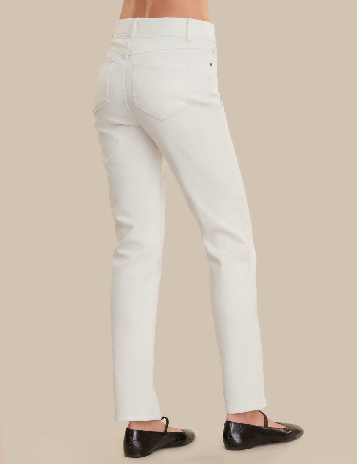 White pants worn by a person on a beige background