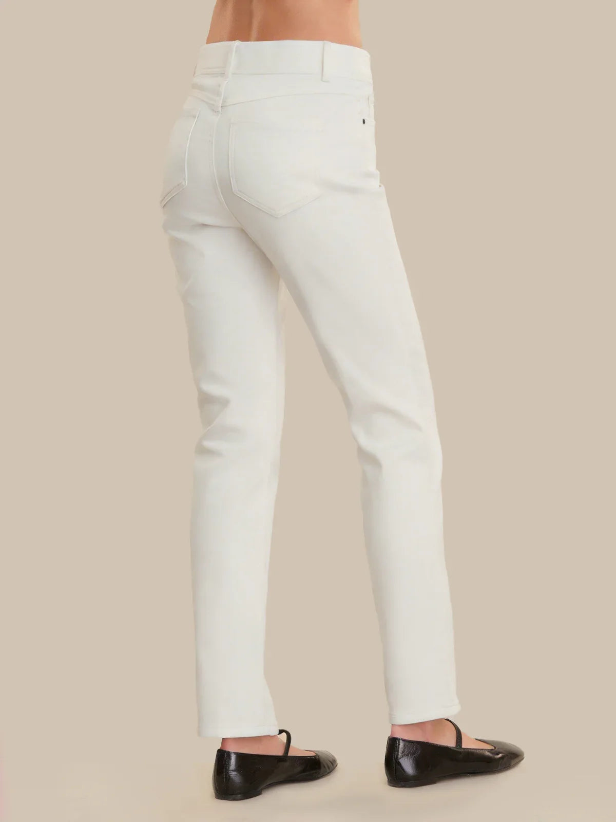 White pants worn by a person on a beige background