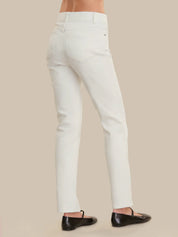 White pants worn by a person on a beige background
