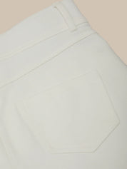 Close-up of light gray pants on a beige background