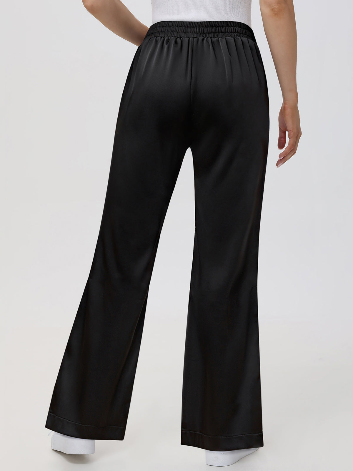 Black wide-leg pants worn by a person on a white background