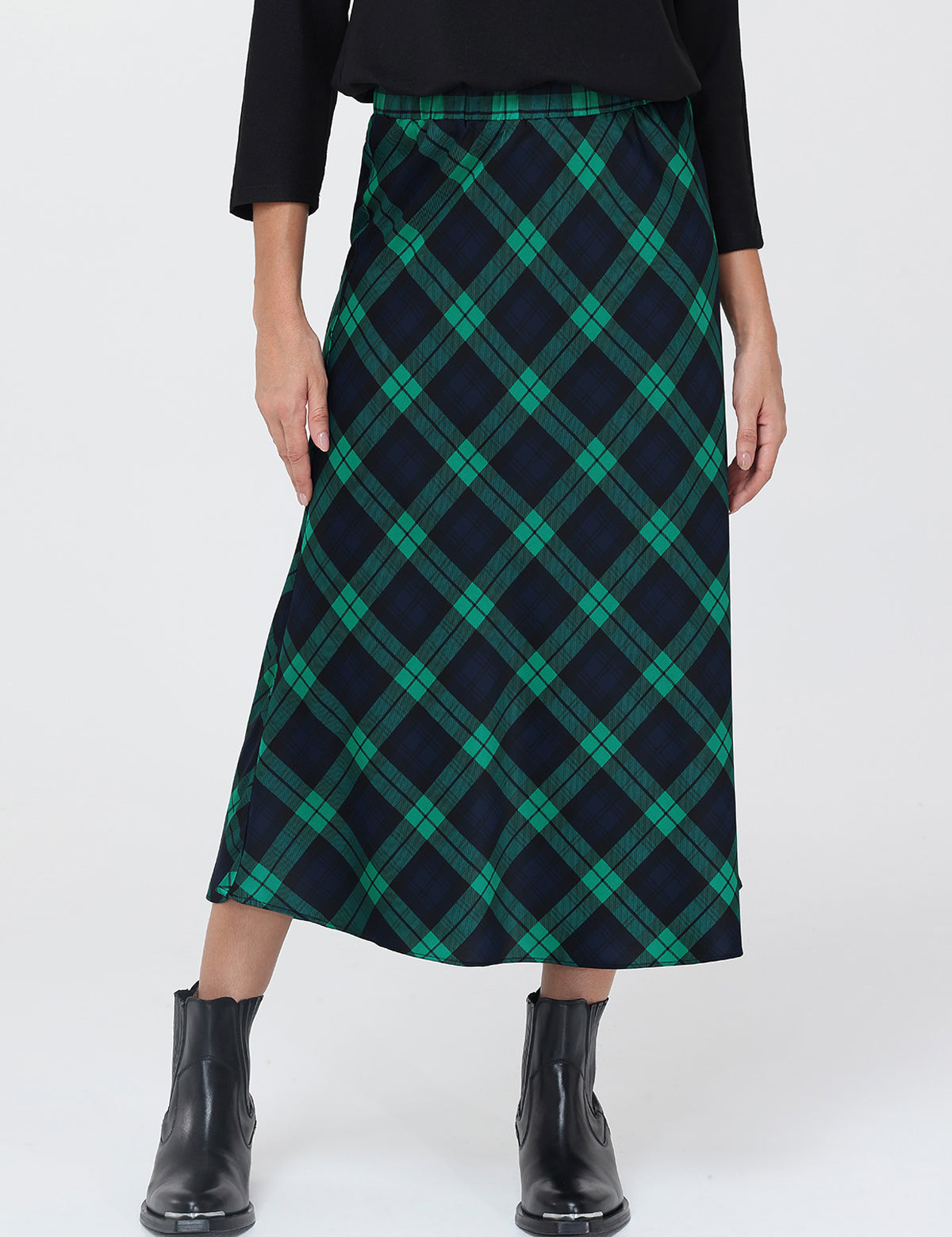 Person wearing a green and navy plaid skirt on a white background