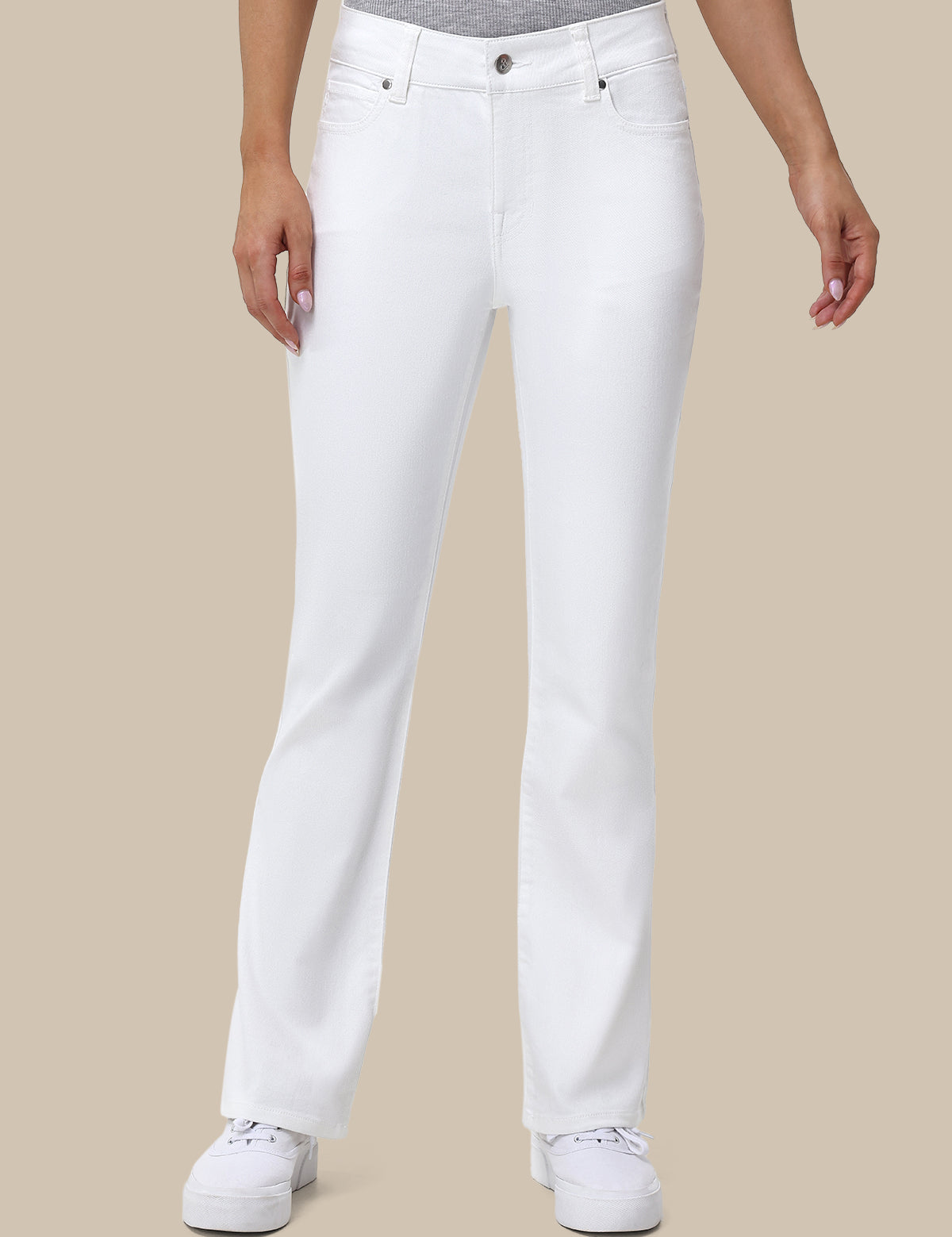 Person wearing white jeans on a beige background