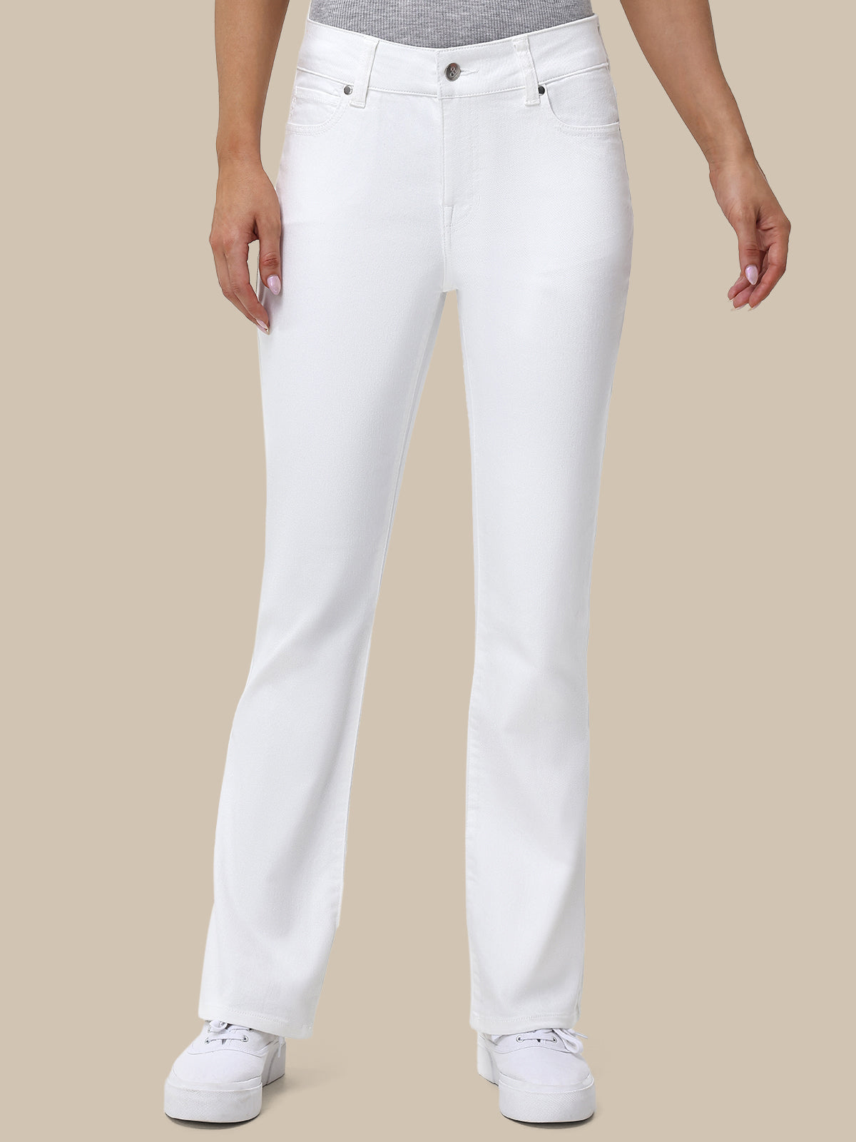 Person wearing white jeans on a beige background