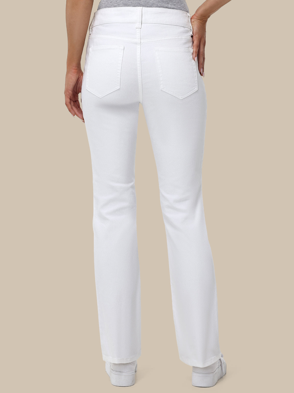 White pants worn by a person on a beige background