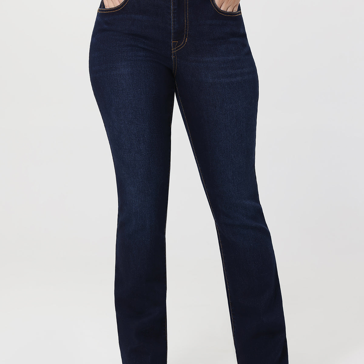 Dark blue jeans worn by a person on a white background