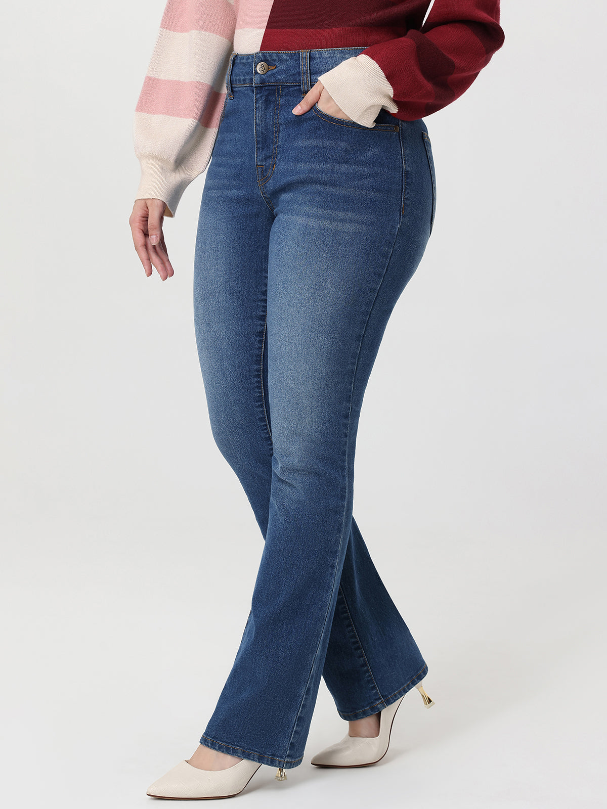 Person wearing blue flared jeans on a white background