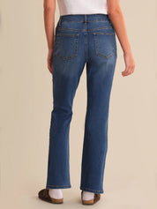 Person wearing blue jeans on a beige background