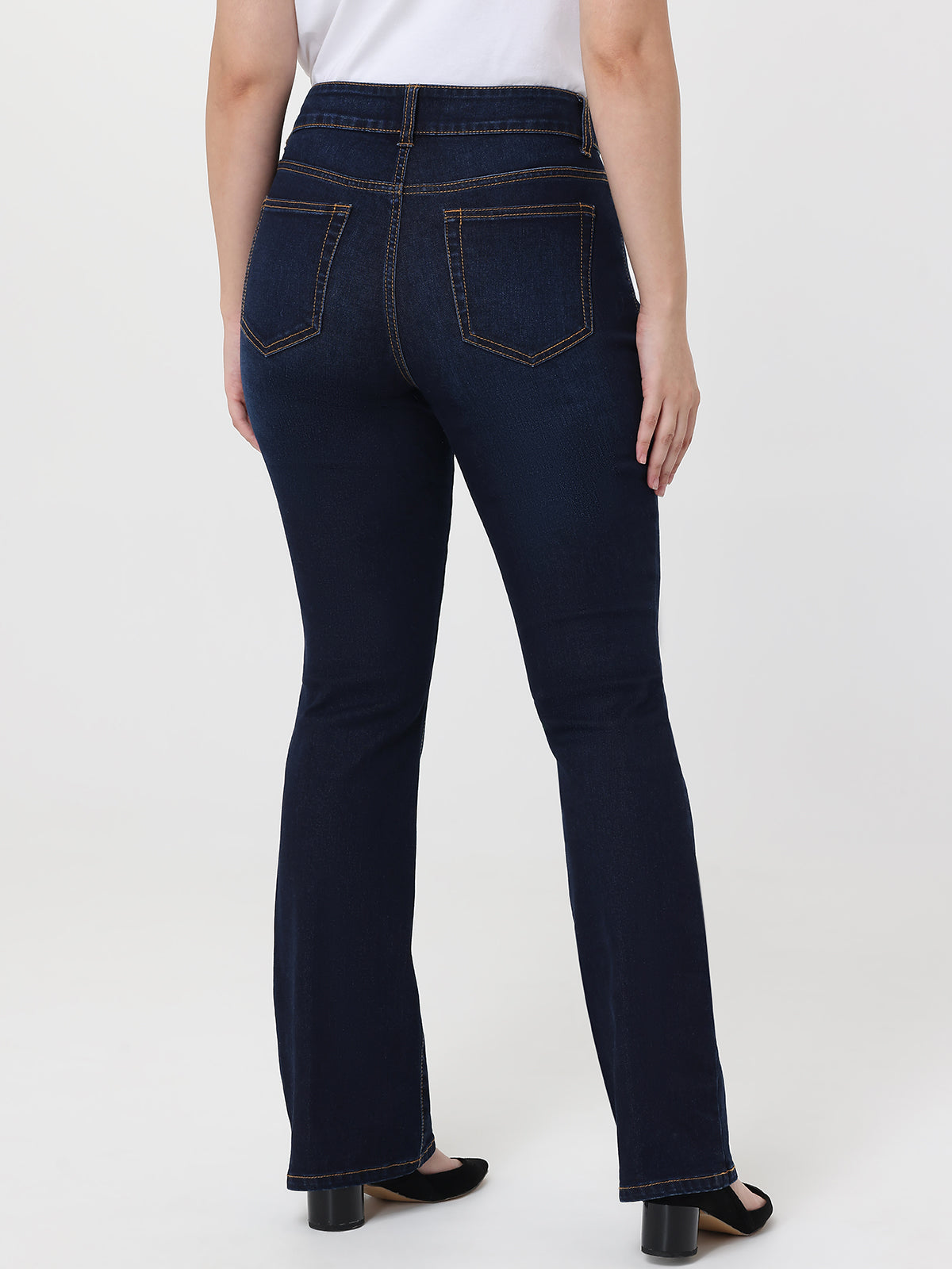 Dark blue jeans worn by a person on a white background