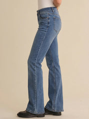 Blue jeans worn by a person on a beige background