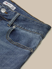 Close-up of blue jeans with a beige background