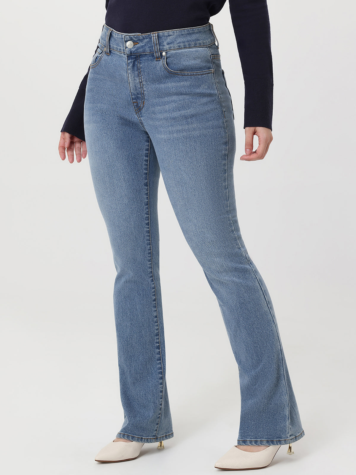 Light blue flared jeans worn by a person on a white background