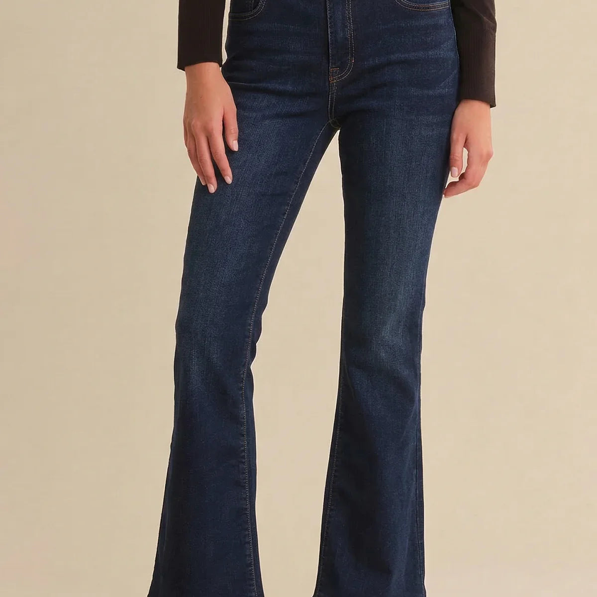 Person wearing blue jeans on a beige background