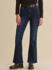 Person wearing blue jeans on a beige background