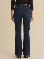 Person wearing blue jeans on a beige background