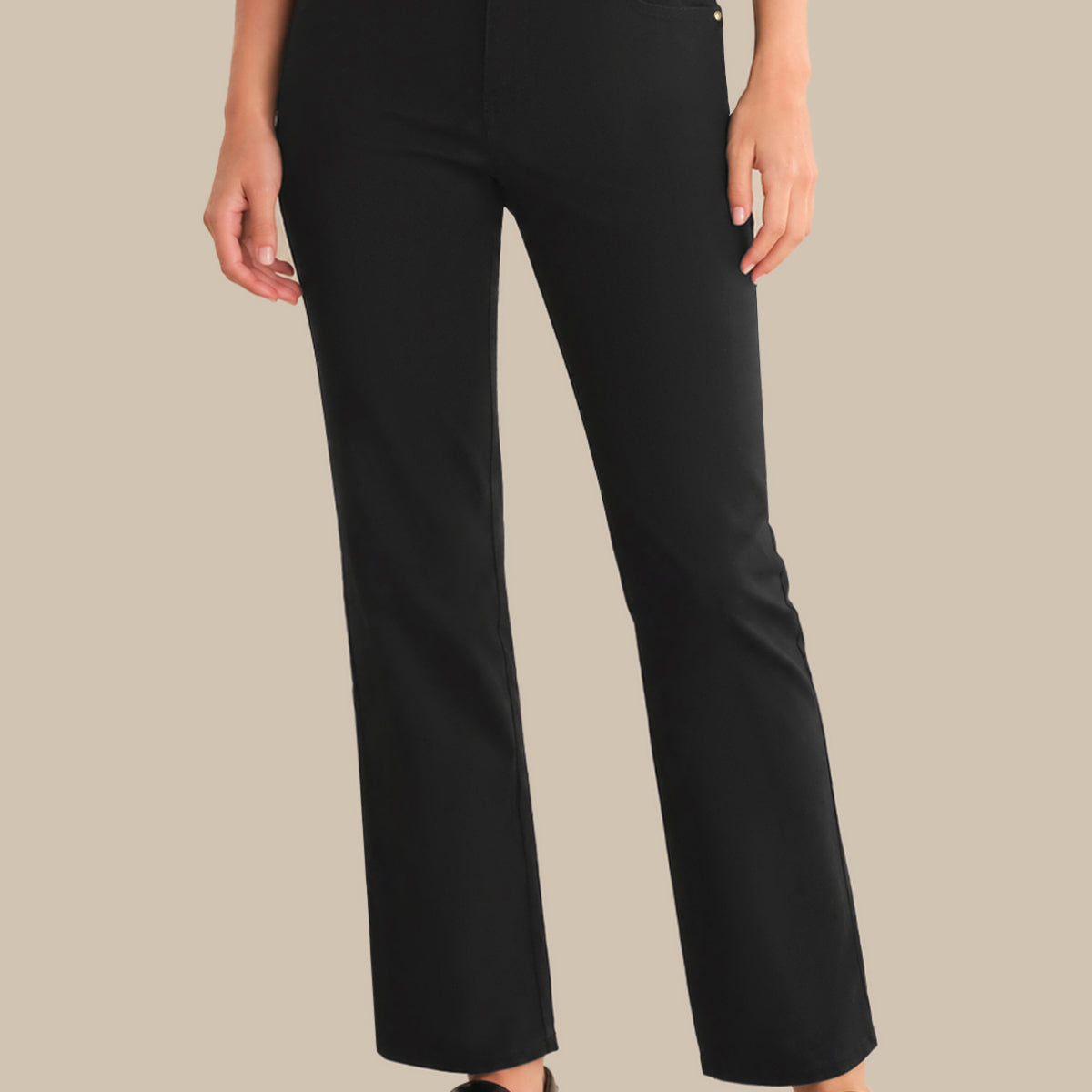 Person wearing black pants on a beige background