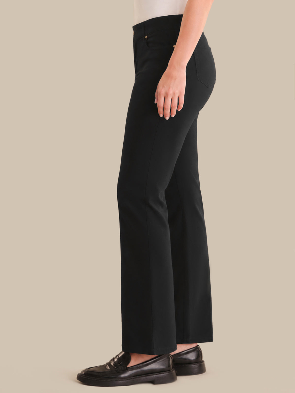 Person wearing black pants on a beige background