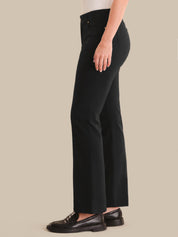 Person wearing black pants on a beige background