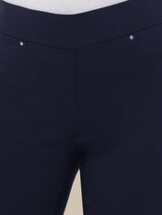 Close-up of dark navy blue pants showing the waistband, front seam, and a small silver rivet detail.