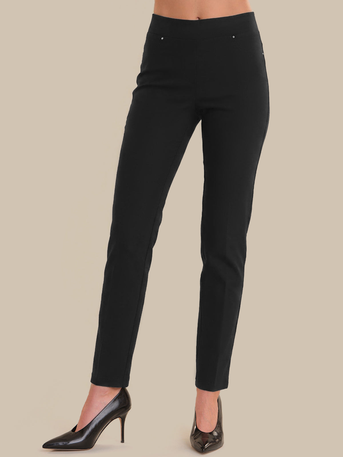 Black pants worn by a person on a beige background