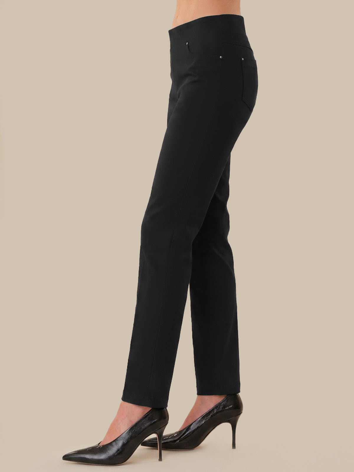 Black pants worn by a person on a beige background