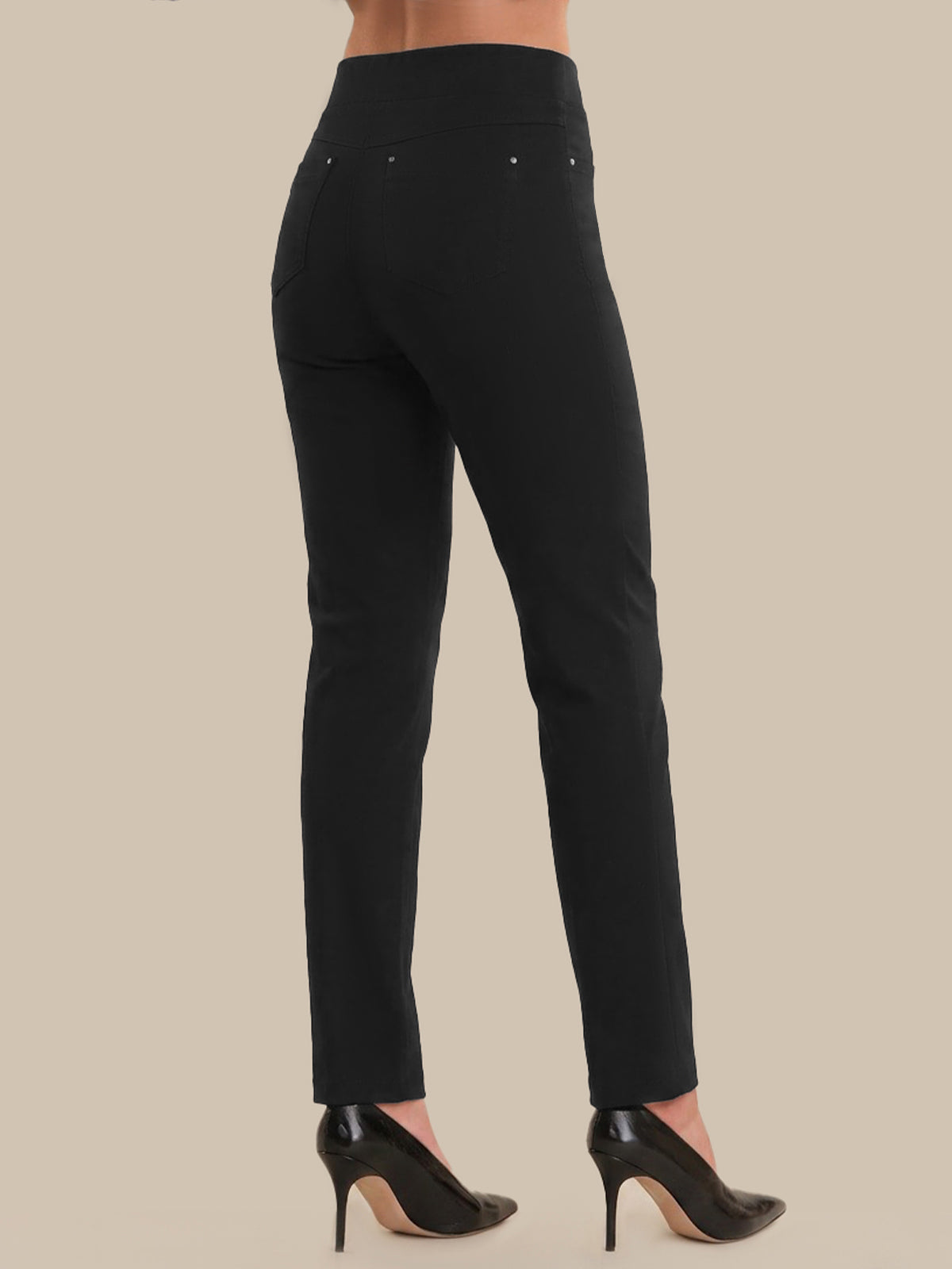 Black pants worn by a person on a beige background