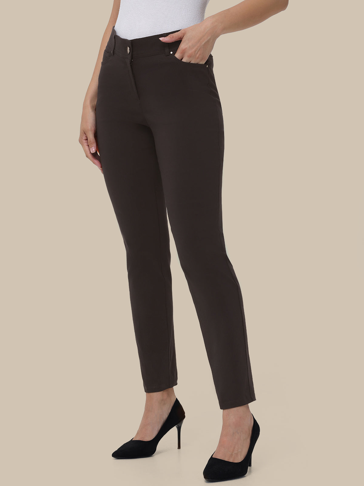 Person wearing brown pants on a beige background