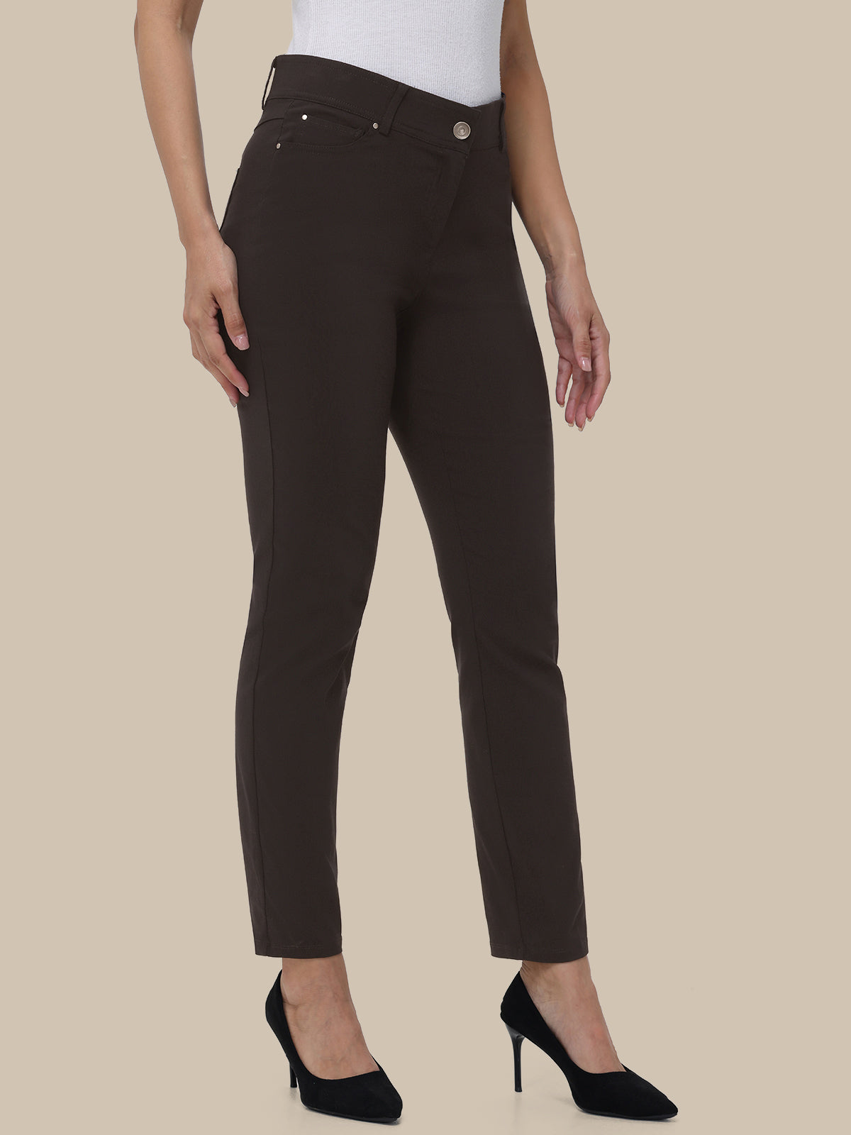 Person wearing brown pants on a beige background